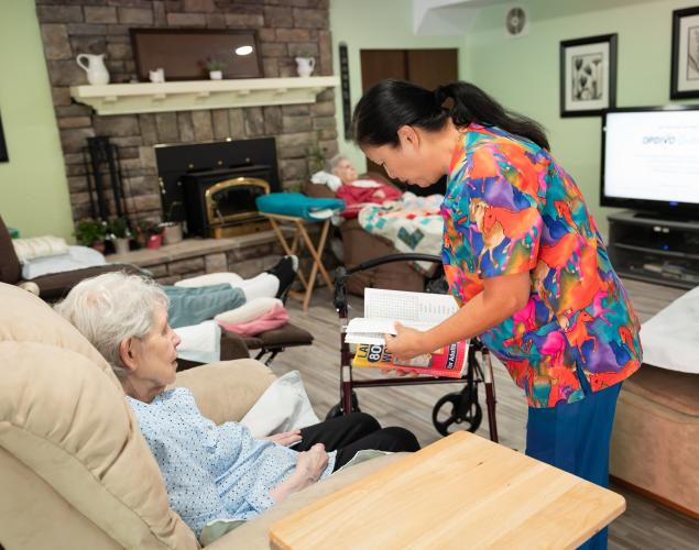 Caregiver helping with a book for a client.