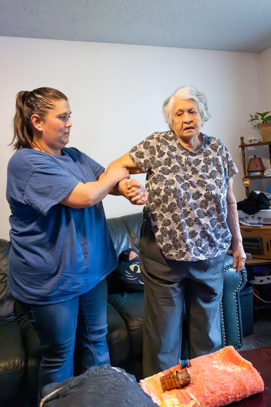 Caregiver helping client stand up.