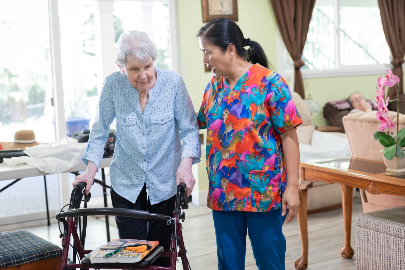 Caregiver provide walking support with client.