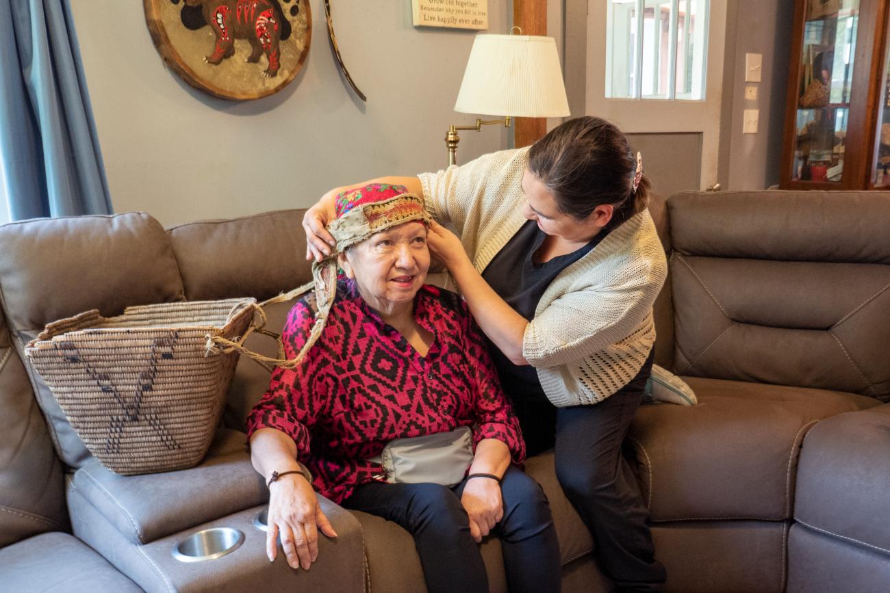 Caregiver interacting with client with Native Head Dress.