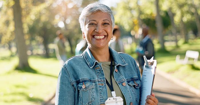 Caregiver smiling while holding a clipboard.