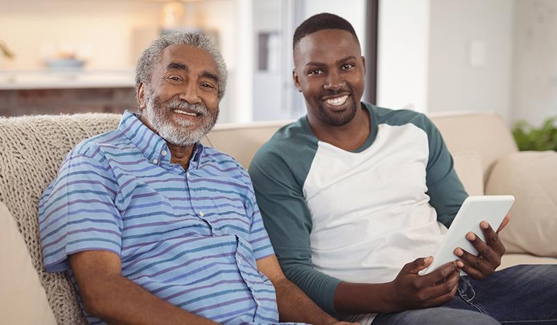 Caregiving sitting on a couch with his client.