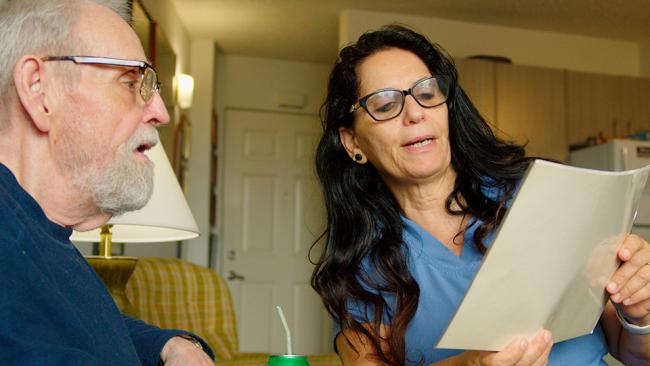 Caregiving showing paperwork to client.