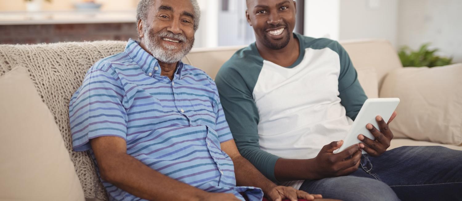 Smiling Caregiver and client sitting on a couch.
