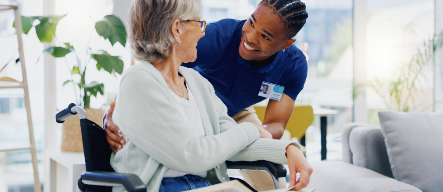 Caregiver engaging with a client in a wheelchair.