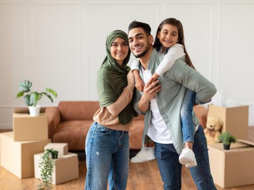 Happy muslim family looking at camera, posing on moving day.